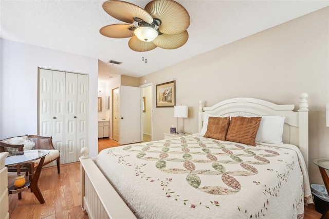 bedroom featuring ensuite bathroom, light wood-type flooring, ceiling fan, and a closet