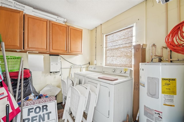 laundry room featuring a textured ceiling, water heater, washing machine and dryer, and cabinets