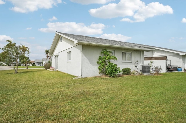 back of property with central air condition unit and a lawn