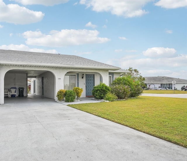 ranch-style home featuring a front lawn and a carport