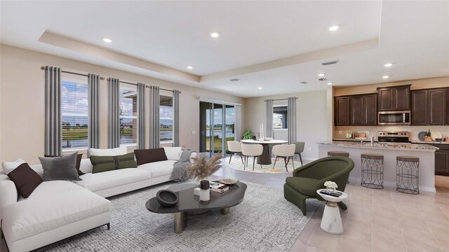 living room with light tile patterned floors and a raised ceiling