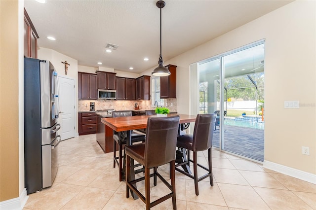 dining area featuring a textured ceiling and light tile patterned floors