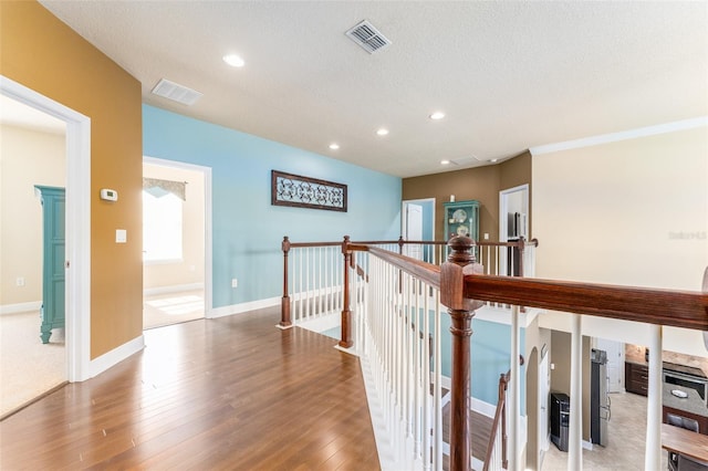 hallway featuring hardwood / wood-style floors and a textured ceiling