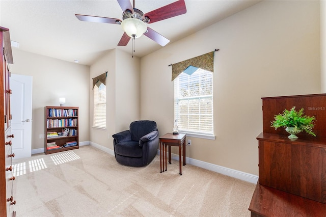 living area with light colored carpet and ceiling fan