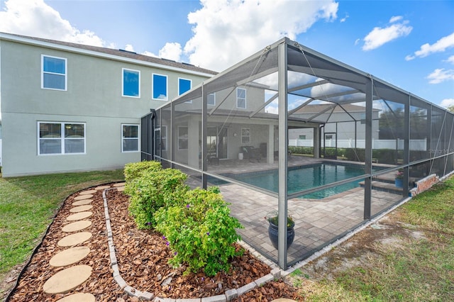 rear view of property with a patio and glass enclosure