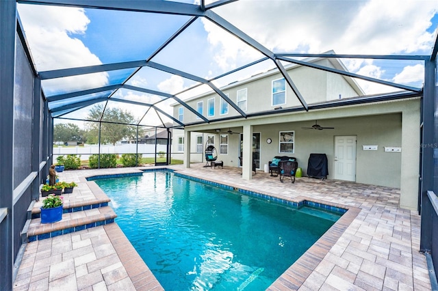 view of swimming pool with ceiling fan, a lanai, and a patio area