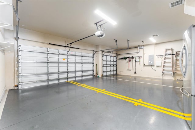 garage featuring electric panel, a garage door opener, and stainless steel refrigerator