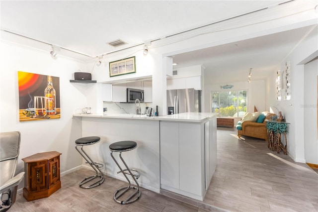 kitchen featuring white cabinets, stainless steel appliances, and kitchen peninsula