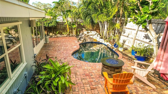 view of pool with a patio and a fire pit