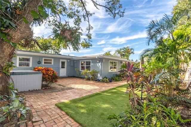 rear view of house featuring a lawn and a patio area