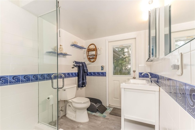 bathroom featuring walk in shower, vanity, tile walls, and hardwood / wood-style floors