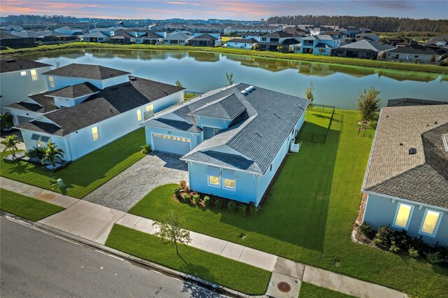 aerial view at dusk featuring a water view