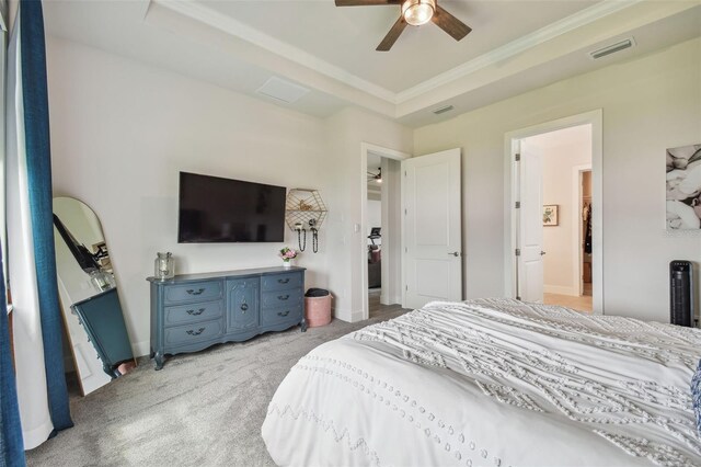 bedroom featuring light carpet, a raised ceiling, and ceiling fan