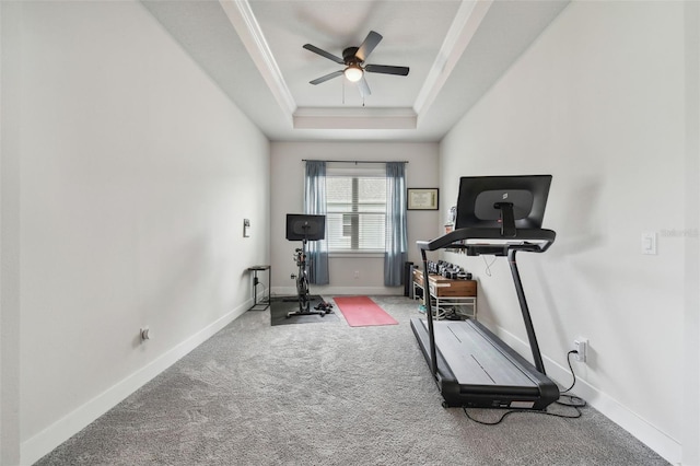 exercise area featuring carpet, ceiling fan, a raised ceiling, and crown molding