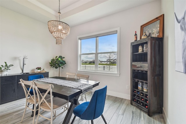 dining area with light hardwood / wood-style floors and a chandelier