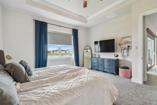 bedroom with a tray ceiling, ceiling fan, and light hardwood / wood-style floors