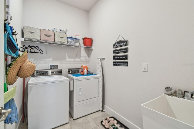 laundry area featuring sink, light tile patterned floors, and independent washer and dryer