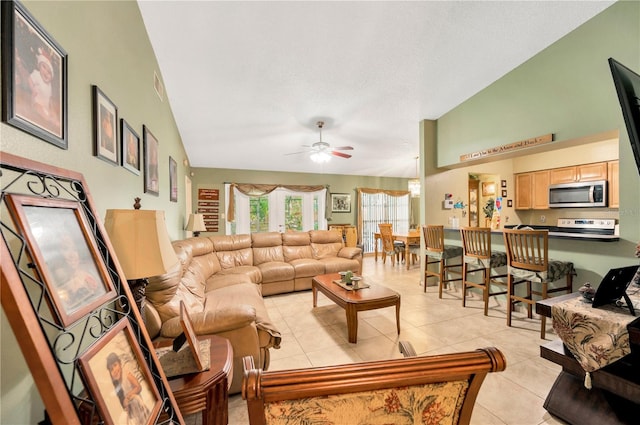 tiled living room with ceiling fan and vaulted ceiling