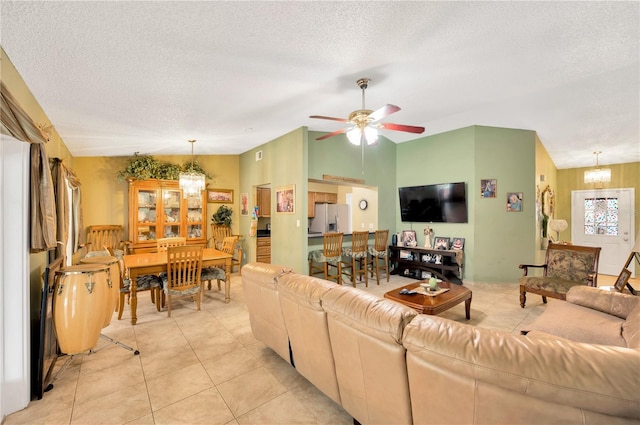 living room with lofted ceiling, a textured ceiling, light tile patterned flooring, and ceiling fan with notable chandelier