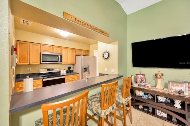 kitchen featuring light tile patterned flooring, kitchen peninsula, and stainless steel appliances