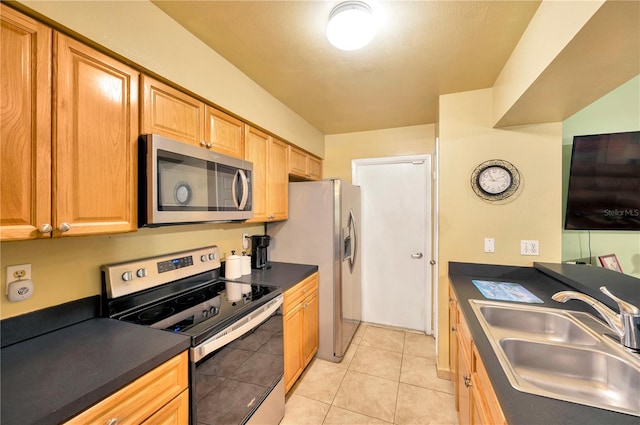 kitchen with sink, light tile patterned flooring, and stainless steel appliances