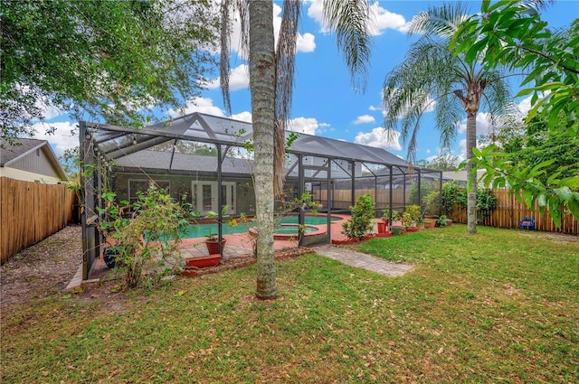 view of yard with glass enclosure, a patio area, and a fenced in pool