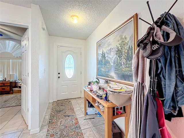 tiled foyer entrance with a textured ceiling