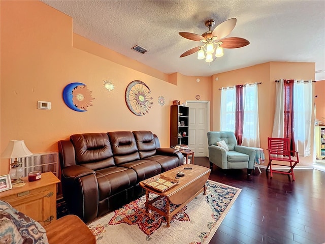 living room featuring a textured ceiling, ceiling fan, and dark hardwood / wood-style flooring