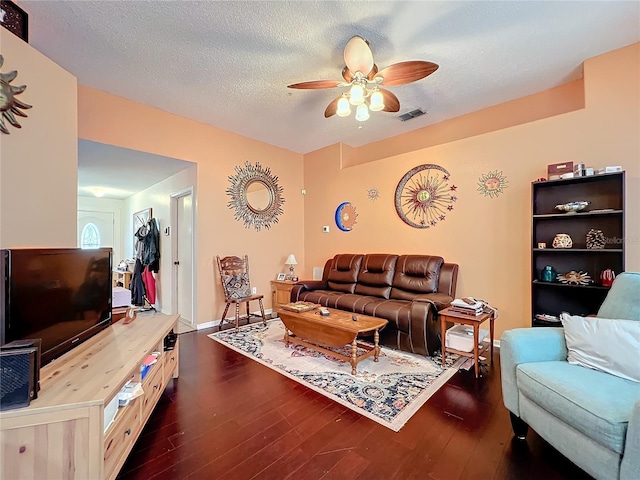 living room featuring dark hardwood / wood-style floors, a textured ceiling, and ceiling fan