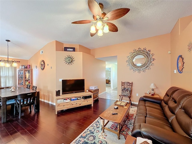 living room featuring lofted ceiling, a textured ceiling, ceiling fan with notable chandelier, and dark hardwood / wood-style flooring