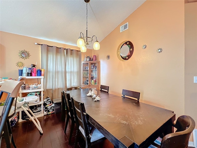 dining space featuring lofted ceiling, dark hardwood / wood-style floors, and an inviting chandelier