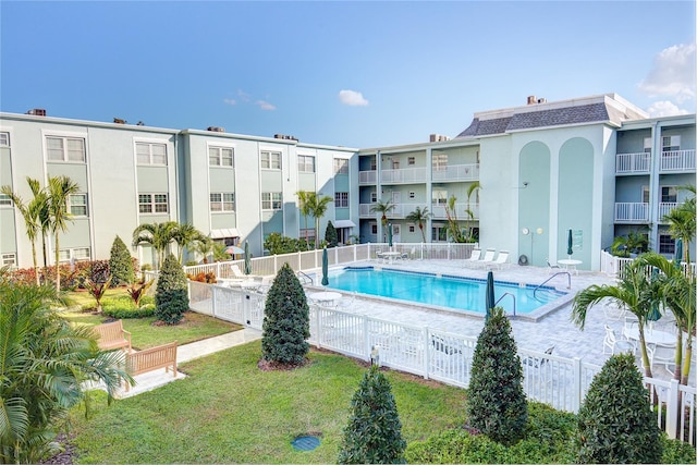 view of pool featuring a lawn