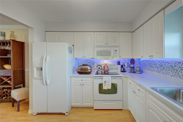 kitchen featuring white cabinets, light wood-type flooring, and white appliances