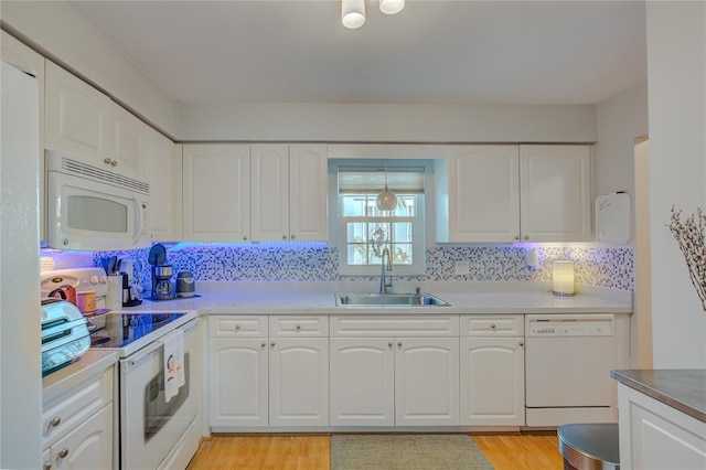 kitchen featuring white appliances, sink, and white cabinets