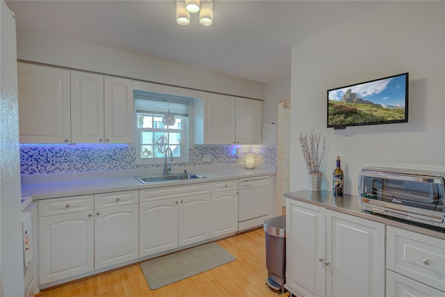 kitchen with white cabinets, dishwasher, and sink