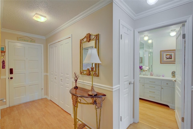 interior space featuring crown molding, a textured ceiling, and light hardwood / wood-style floors