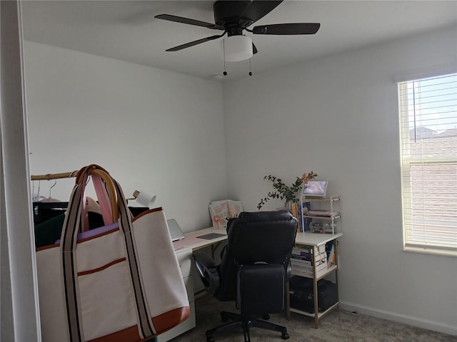 carpeted home office with ceiling fan and a healthy amount of sunlight