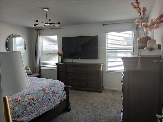 carpeted bedroom with multiple windows, a textured ceiling, and ceiling fan with notable chandelier