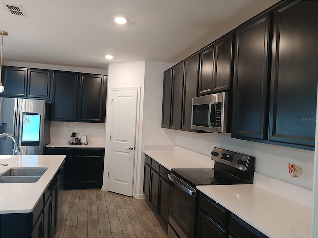 kitchen with stainless steel appliances, sink, and light wood-type flooring