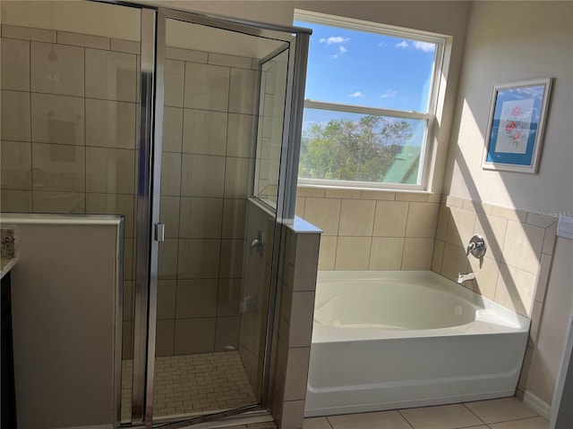 bathroom with separate shower and tub and tile patterned flooring