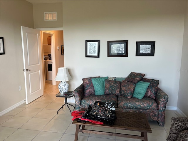 tiled living room featuring washer / dryer