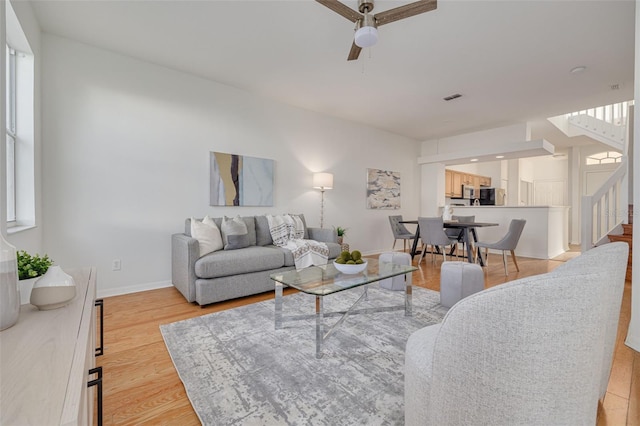 living room with light hardwood / wood-style floors and ceiling fan