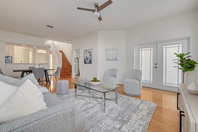 living room featuring light hardwood / wood-style floors, french doors, and ceiling fan