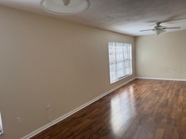 empty room featuring ceiling fan and dark hardwood / wood-style floors