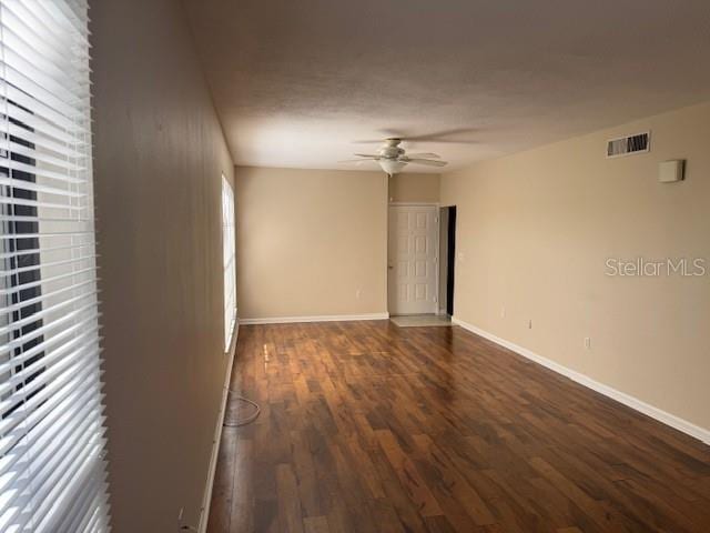 spare room featuring ceiling fan and dark hardwood / wood-style flooring