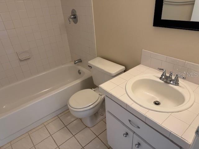 full bathroom featuring decorative backsplash, toilet, tile patterned flooring, tiled shower / bath combo, and vanity