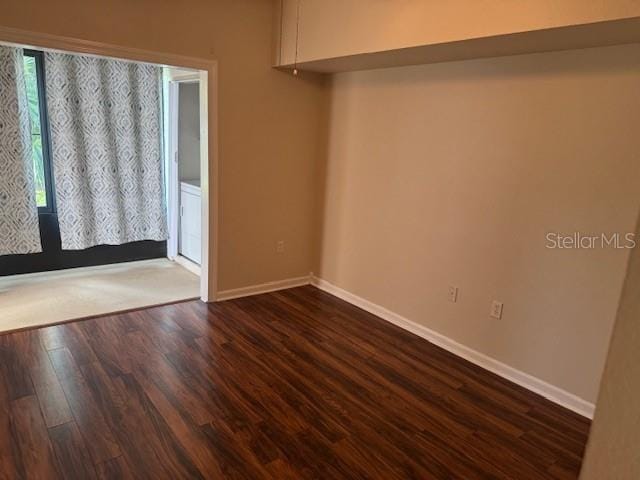 unfurnished room with dark hardwood / wood-style floors