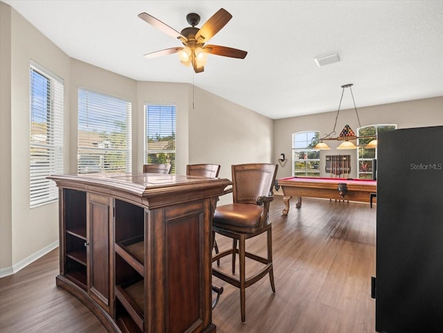 bar with billiards, a wealth of natural light, decorative light fixtures, and hardwood / wood-style floors