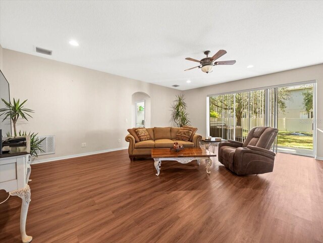 living room with ceiling fan and dark hardwood / wood-style flooring