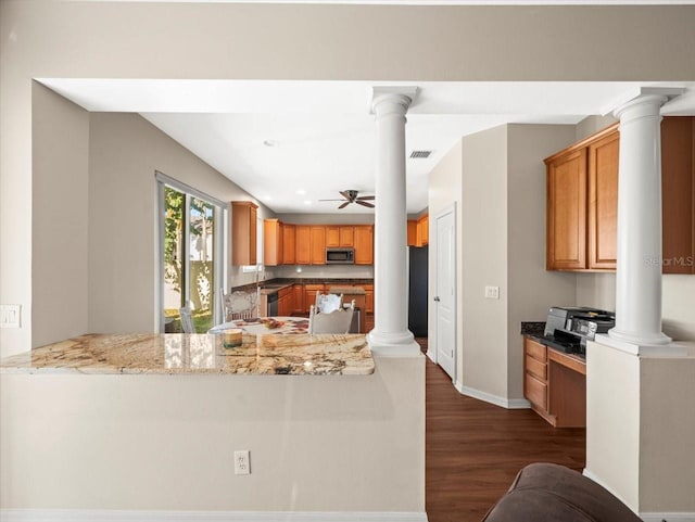 kitchen with ceiling fan, light stone countertops, kitchen peninsula, and dark hardwood / wood-style floors